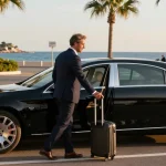 Transfert aéroport Nice : Chauffeur privé accueillant un client à l'aéroport avec une vue sur la Côte d'Azur.